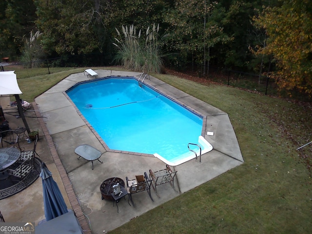 view of swimming pool featuring a lawn, a patio area, and a diving board