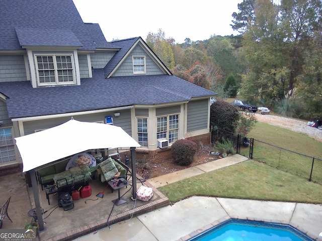 rear view of house with a yard, a fenced in pool, cooling unit, and a patio area