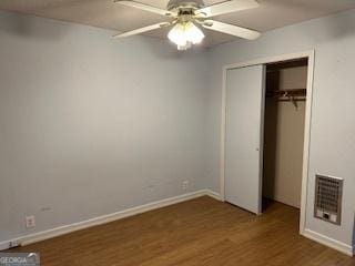 unfurnished bedroom featuring a closet, ceiling fan, and dark wood-type flooring