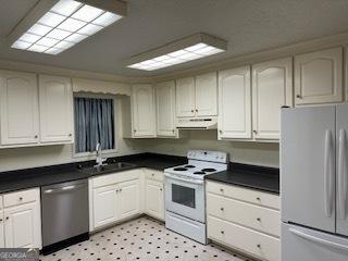 kitchen with sink, white cabinets, and white appliances