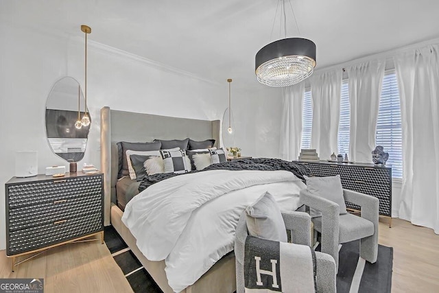 bedroom featuring multiple windows, a chandelier, and light hardwood / wood-style floors