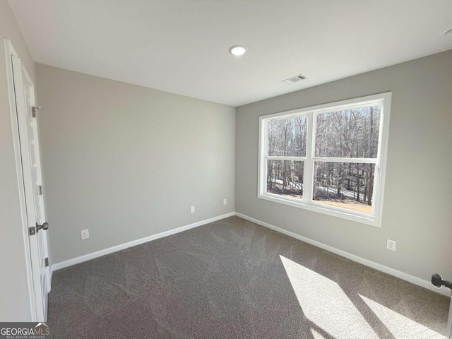 empty room with dark colored carpet