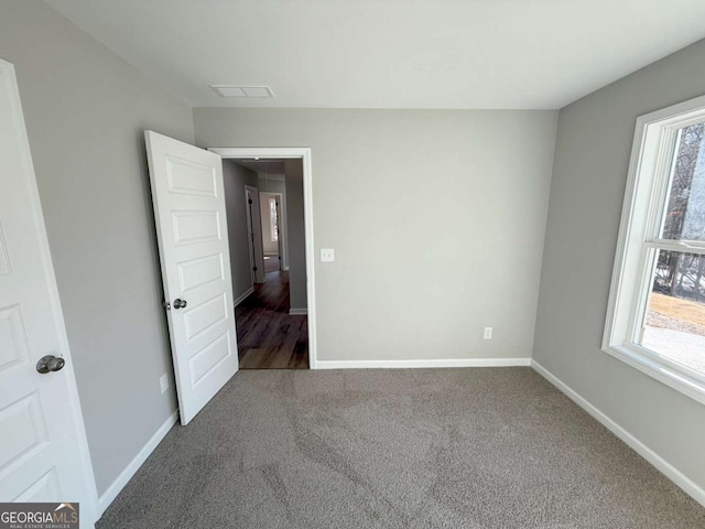 empty room with carpet floors and a wealth of natural light