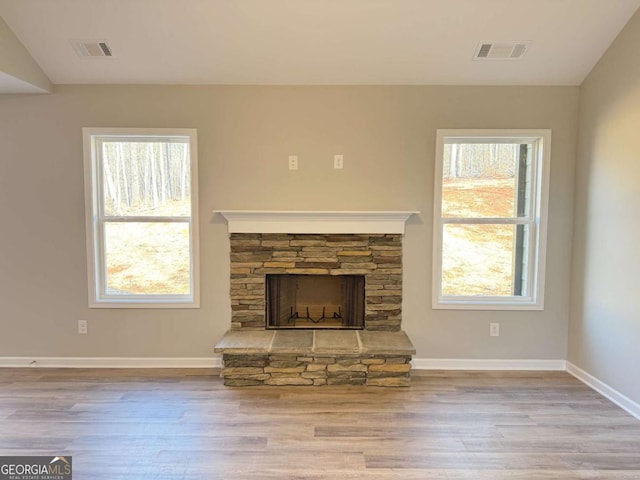 unfurnished living room with light hardwood / wood-style floors, a fireplace, and vaulted ceiling