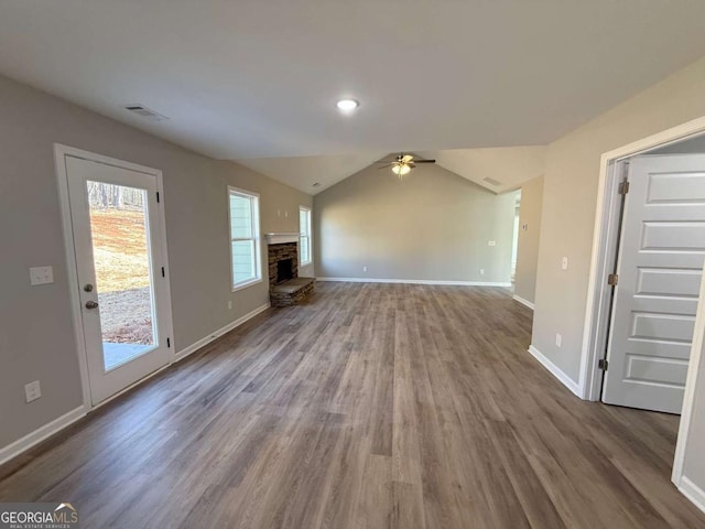 unfurnished living room with a fireplace, hardwood / wood-style flooring, vaulted ceiling, and ceiling fan