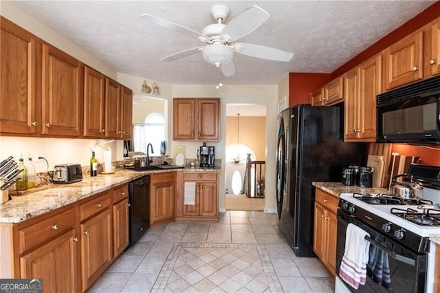 kitchen with a textured ceiling, ceiling fan, sink, black appliances, and light tile patterned flooring