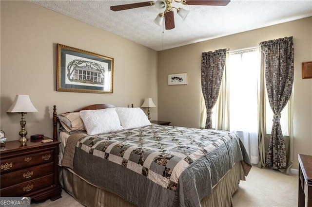 carpeted bedroom featuring ceiling fan and a textured ceiling