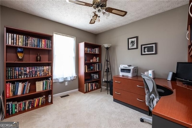 carpeted home office featuring ceiling fan and a textured ceiling