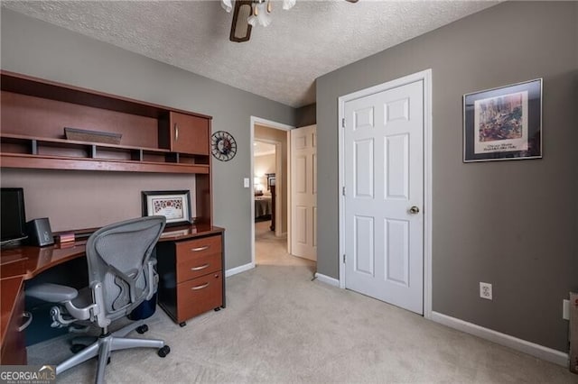 carpeted office featuring a textured ceiling and ceiling fan