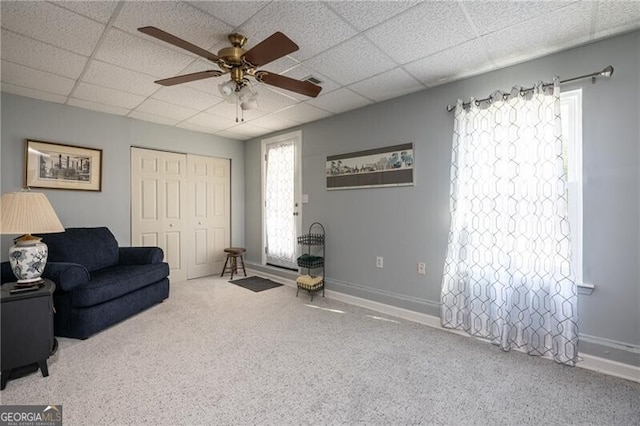 living room featuring a paneled ceiling and ceiling fan