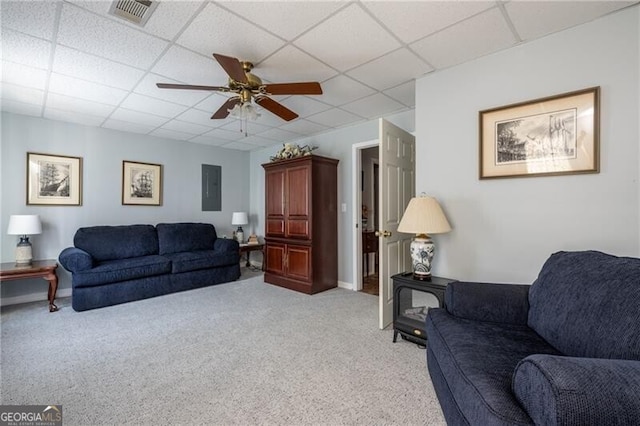 living room featuring a paneled ceiling, ceiling fan, and light colored carpet