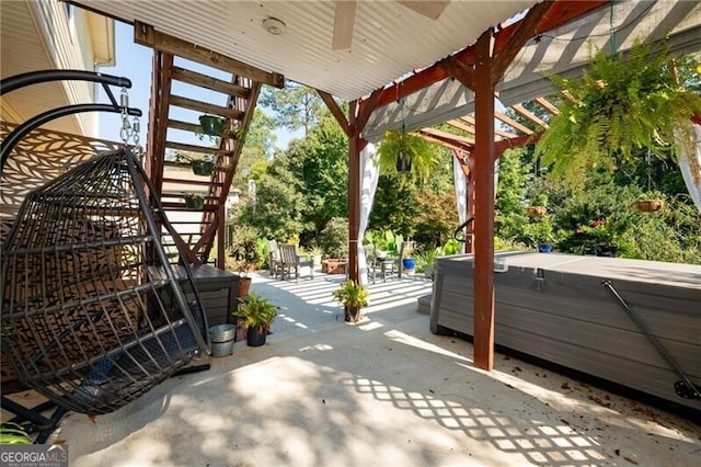 view of patio with ceiling fan and a hot tub