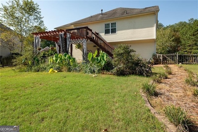 rear view of property with a pergola and a lawn