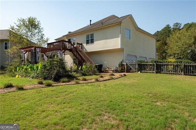 back of property with a pergola, a yard, and a deck