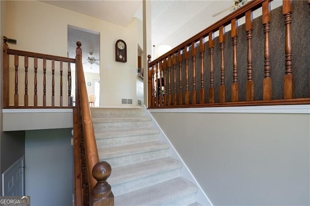 stairway featuring ceiling fan