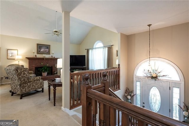 hallway with lofted ceiling, light carpet, and an inviting chandelier