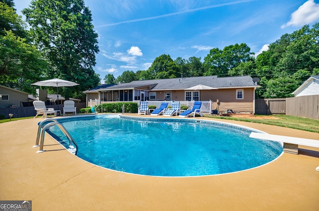 view of pool featuring a diving board, a patio area, and a sunroom