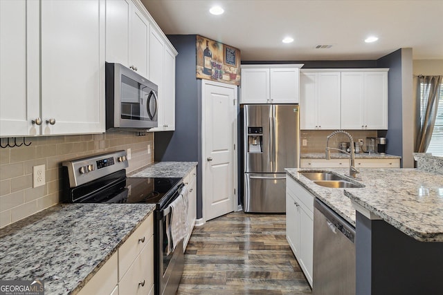 kitchen with white cabinetry, sink, tasteful backsplash, dark hardwood / wood-style floors, and appliances with stainless steel finishes