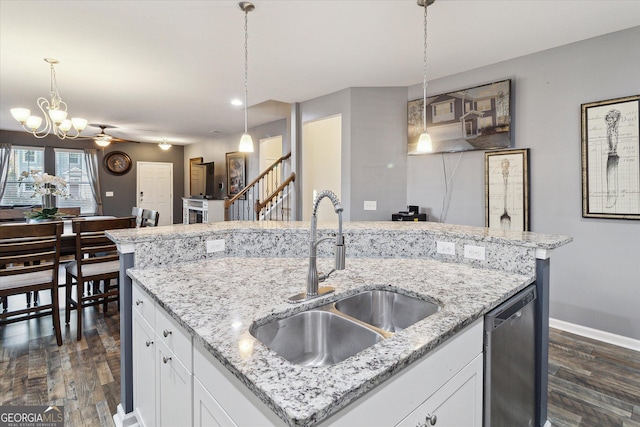 kitchen featuring pendant lighting, white cabinets, ceiling fan with notable chandelier, sink, and stainless steel dishwasher