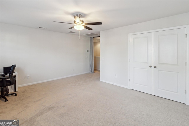 interior space with ceiling fan and light colored carpet