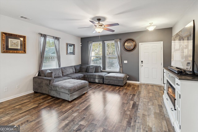 living room featuring plenty of natural light, ceiling fan, and dark wood-type flooring