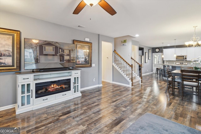 living room featuring ceiling fan and dark hardwood / wood-style floors