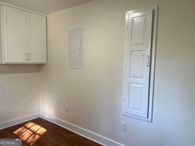 washroom with electric panel and dark wood-type flooring