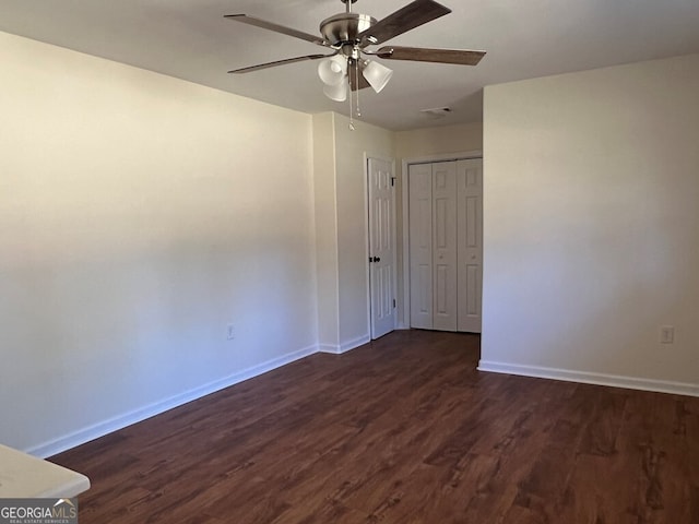 unfurnished room with dark hardwood / wood-style floors and ceiling fan