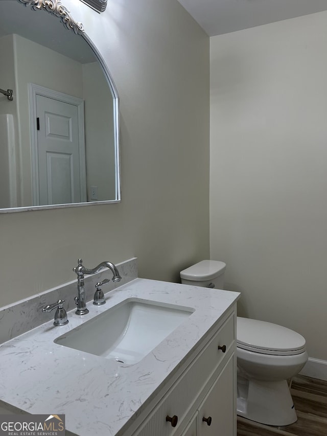 bathroom featuring hardwood / wood-style floors, vanity, and toilet