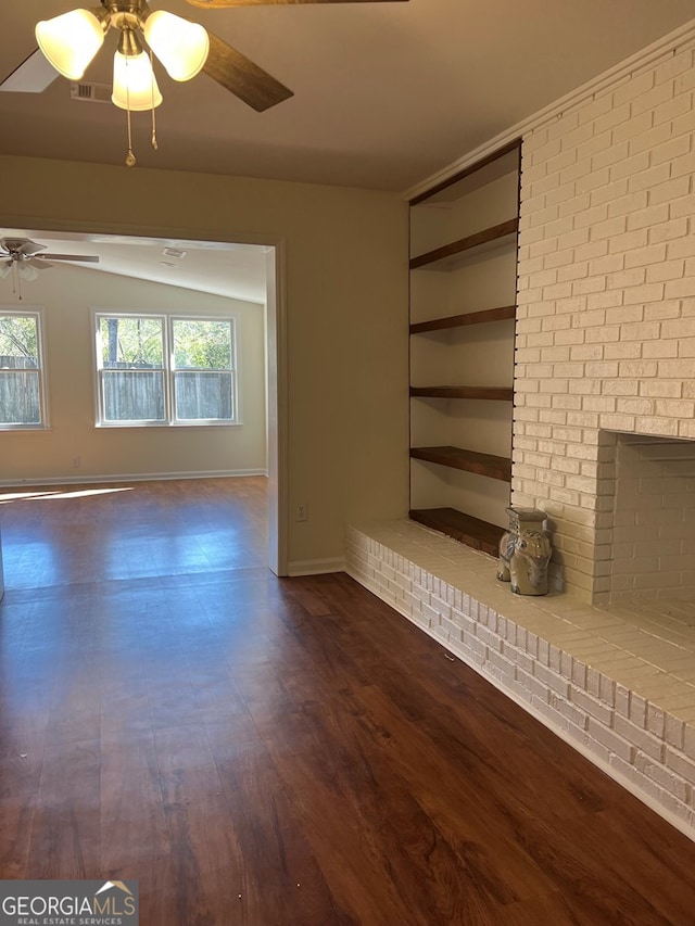 unfurnished living room featuring a fireplace, dark hardwood / wood-style flooring, and ceiling fan