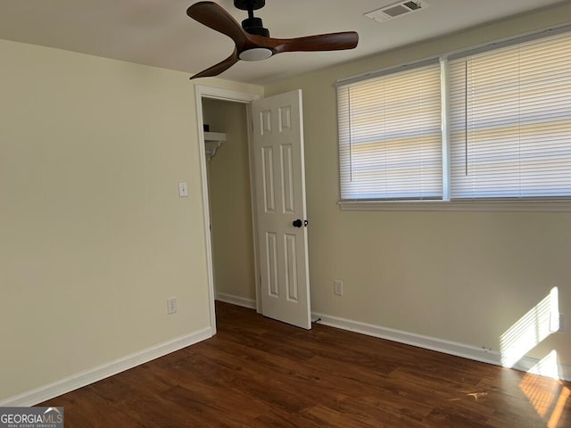 unfurnished bedroom with a closet, ceiling fan, and dark wood-type flooring