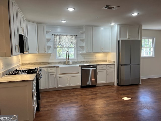 kitchen with plenty of natural light, white cabinetry, sink, and appliances with stainless steel finishes