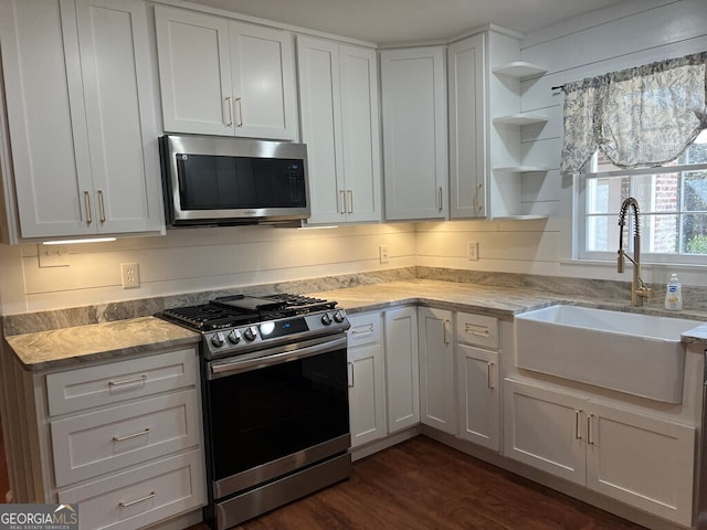 kitchen with dark hardwood / wood-style flooring, white cabinetry, sink, and stainless steel appliances