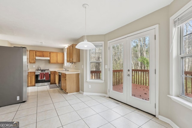 kitchen with a wealth of natural light, sink, french doors, hanging light fixtures, and appliances with stainless steel finishes