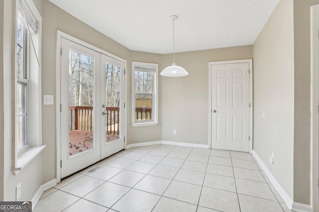 unfurnished dining area with french doors and light tile patterned floors