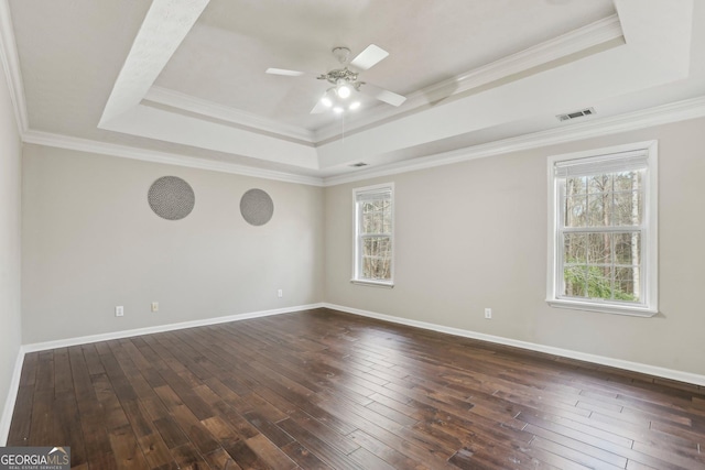 spare room featuring dark hardwood / wood-style floors, a raised ceiling, and crown molding