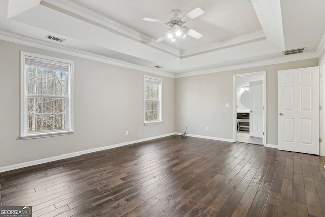 spare room with a tray ceiling, ceiling fan, and dark hardwood / wood-style floors