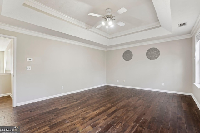 empty room with dark hardwood / wood-style flooring, a raised ceiling, ceiling fan, and crown molding