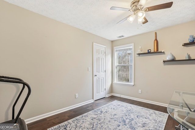 interior space featuring a textured ceiling, dark hardwood / wood-style flooring, and ceiling fan