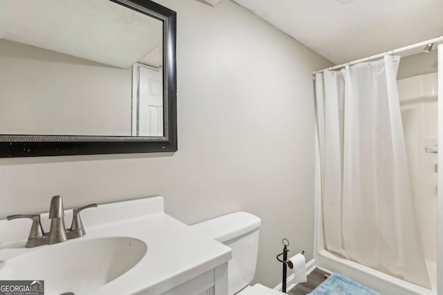 bathroom featuring a shower with curtain, vanity, and toilet