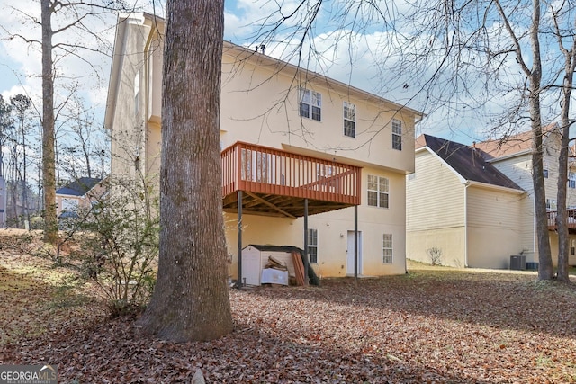 rear view of house featuring central AC unit and a deck