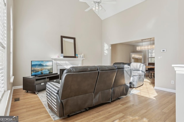 living room with ceiling fan, high vaulted ceiling, and light hardwood / wood-style floors