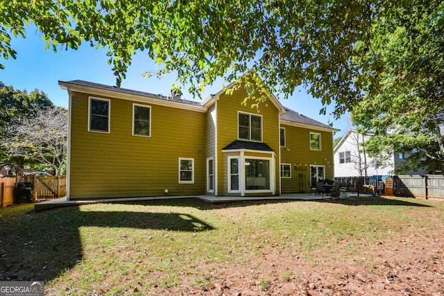 rear view of property with a yard and a patio