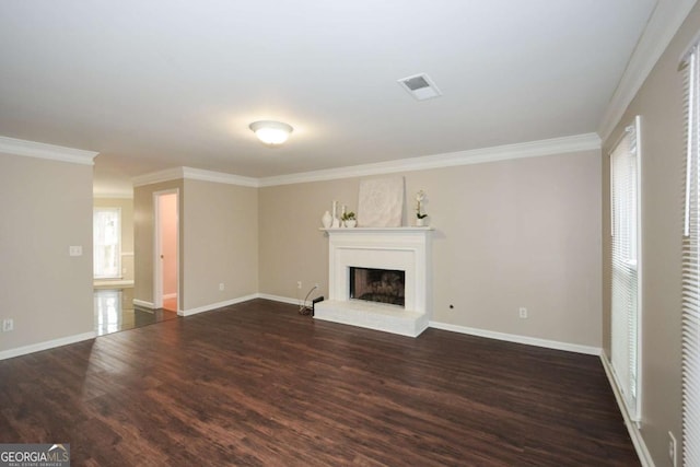 unfurnished living room featuring a fireplace, dark hardwood / wood-style floors, a wealth of natural light, and ornamental molding