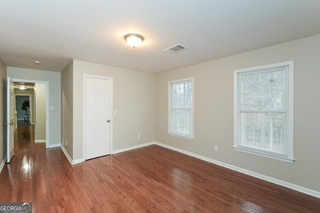 unfurnished room with dark wood-type flooring