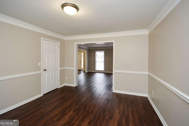 spare room with dark wood-type flooring and crown molding