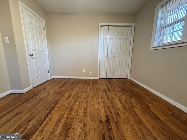 unfurnished bedroom featuring a closet and wood-type flooring