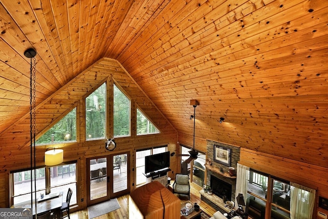 unfurnished living room featuring wood-type flooring, wooden ceiling, a fireplace, and high vaulted ceiling