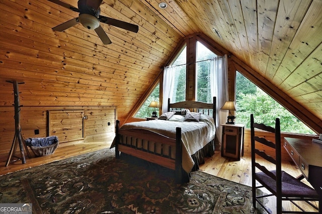 bedroom with ceiling fan, wood walls, wood ceiling, and lofted ceiling