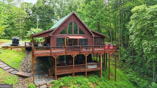 rear view of house featuring a sunroom and a deck